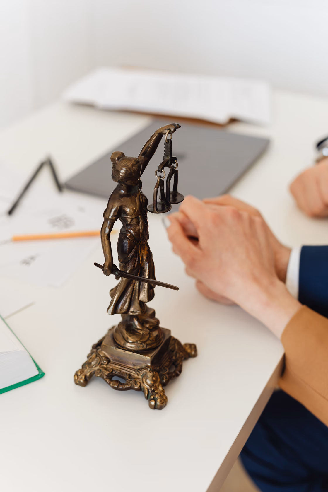 A bronze figure of Lady Justice standing on a lawyer’s desk